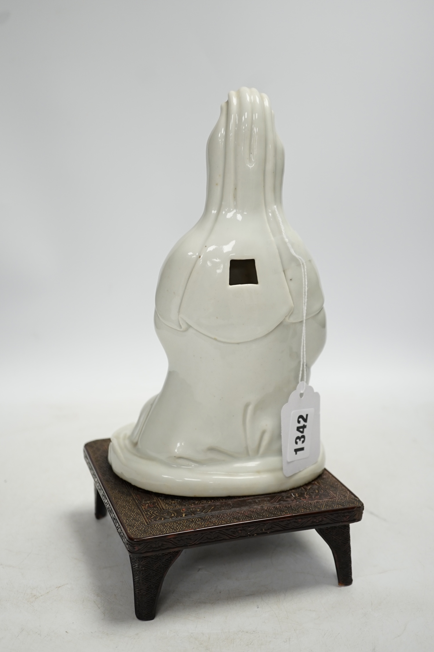 An 18th century Chinese white glazed pottery model of Guanyin on a square hardwood stand, figure 23cm. Condition - poor, hand missing, chips